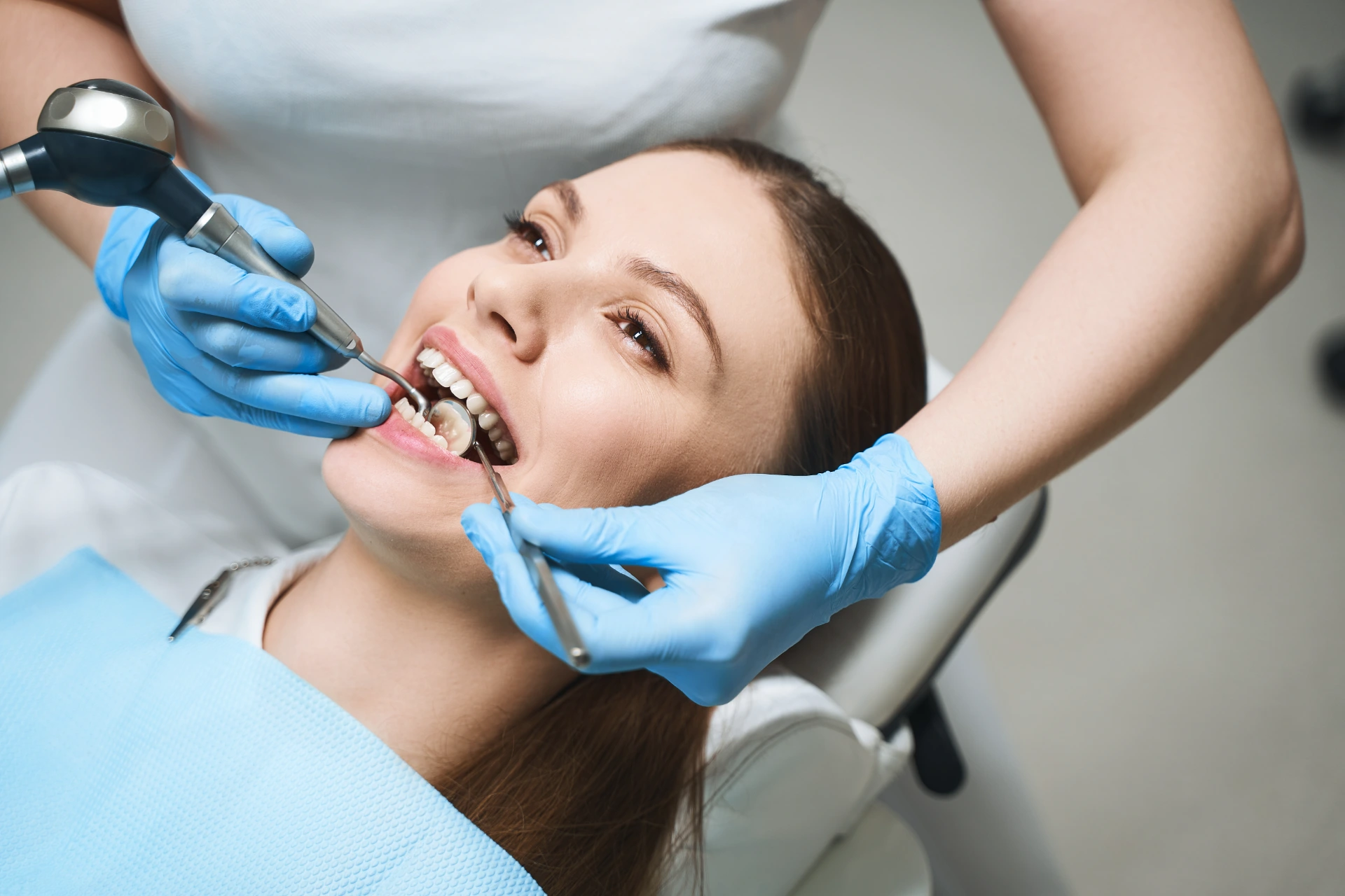 Attractive female is visiting dentist and being given root canal by specialist with modern equipment
