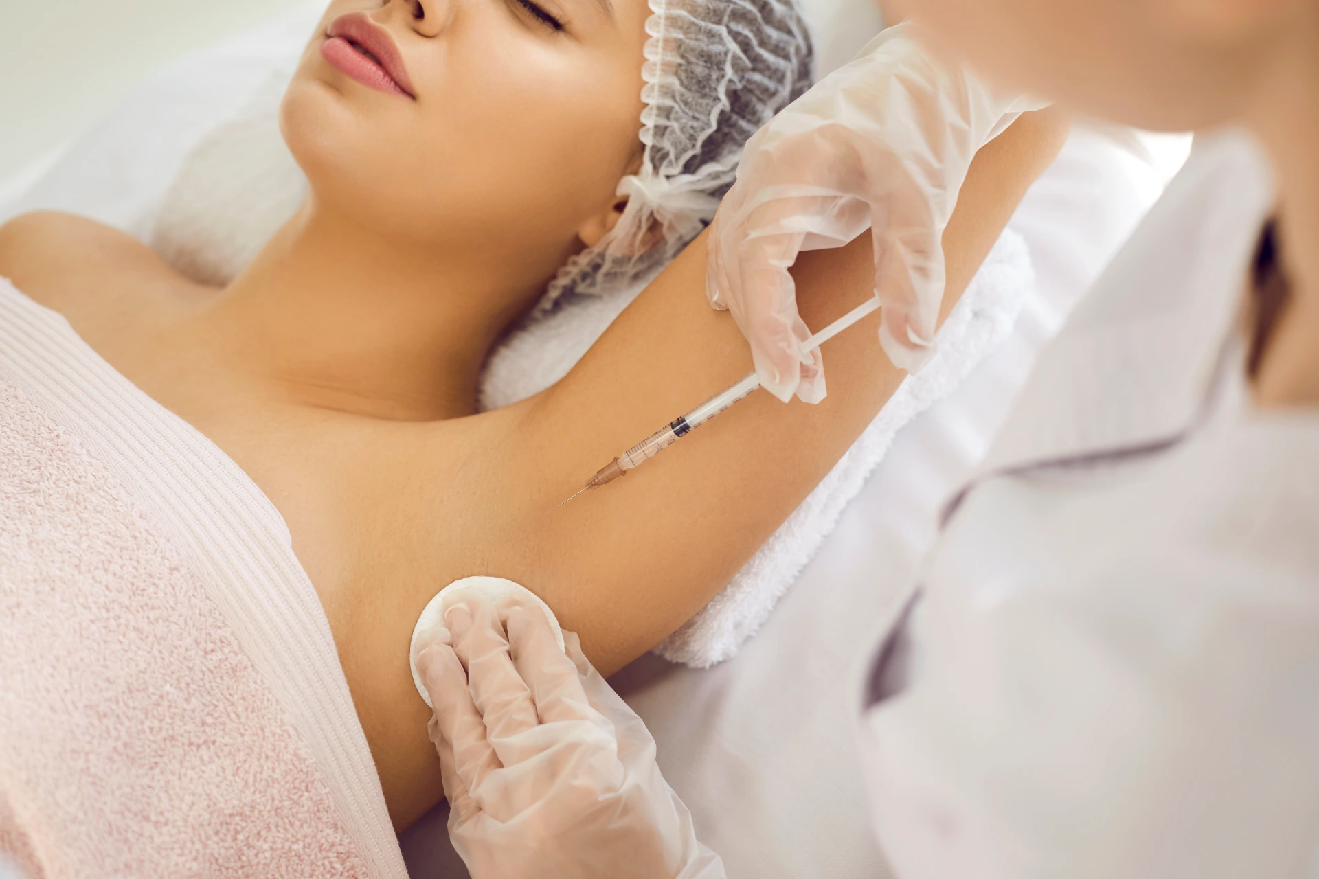 Doctor gives injection in underarm area to reduce armpit sweating, treat hyperhidrosis, prevent bad smell and body odor. Professional injecting glutathione to whiten skin color hyperpigmentation