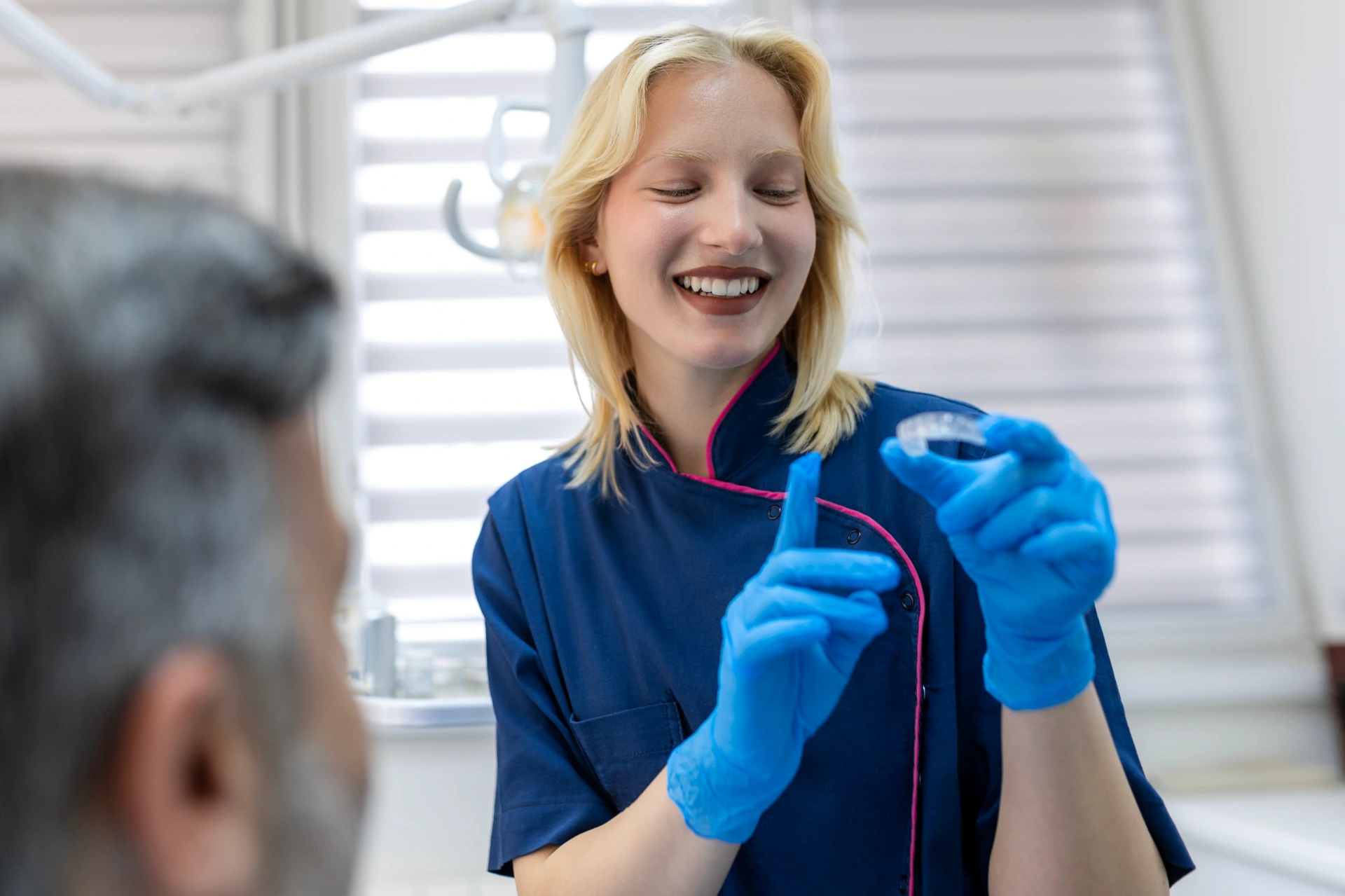 Dentist shows invisible braces aligner. Dental consultation in an orthodontic clinic. Orthodontic removable straighteners in dentist office. Dental treatment concept.