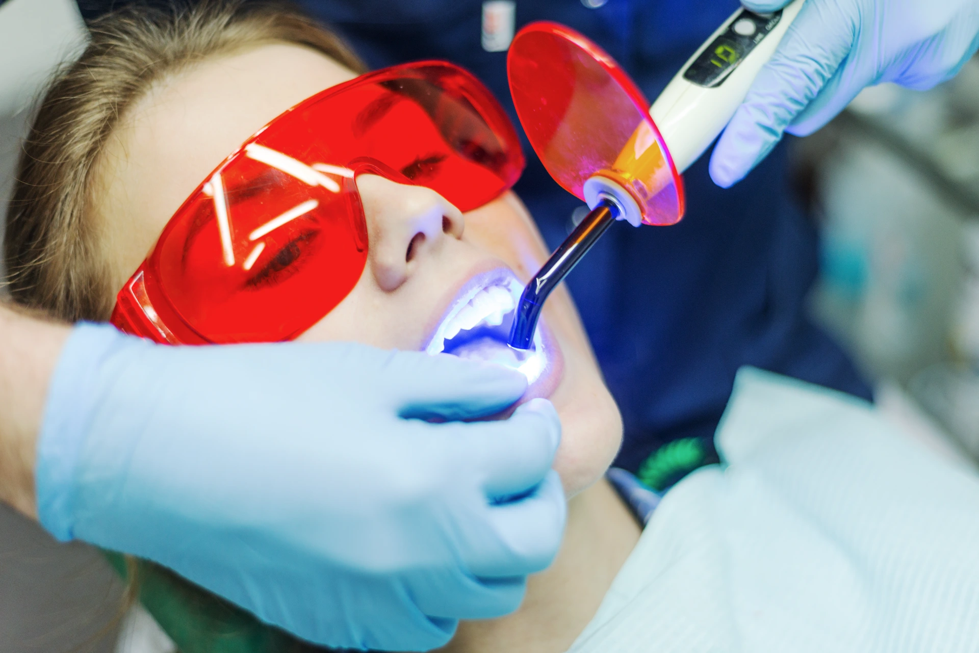 Close-up portrait of a female patient visiting dentist for teeth whitening in clinic